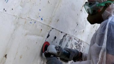 İşçiler tersanede tamirat sürecinde metali boyayla parçalıyorlar..