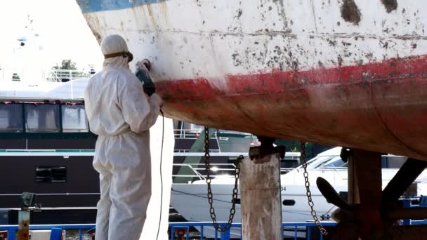 Εργαζόμενοι σχίζουν μπογιά σε μέταλλο κατά τη διαδικασία επισκευής στο ναυπηγείο. — Αρχείο Βίντεο