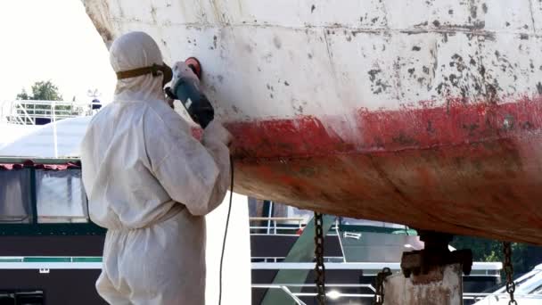 Εργαζόμενοι σχίζουν μπογιά σε μέταλλο κατά τη διαδικασία επισκευής στο ναυπηγείο. — Αρχείο Βίντεο