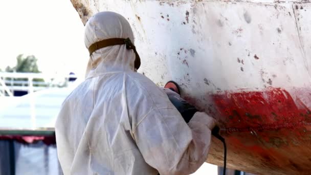 Workers tear off paint on metal in repairs process at shipyard. — Stock Video