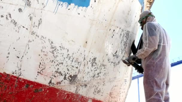 Workers tear off paint on metal in repairs process at shipyard. — Stock Video