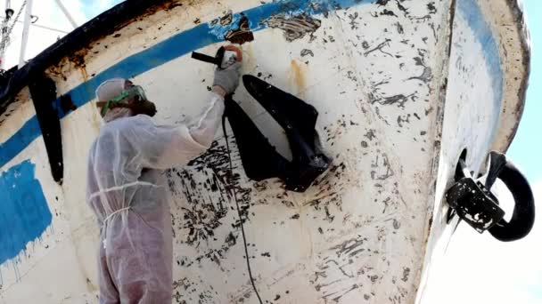 Рабочие отрывают краску от металла в процессе ремонта на верфи. — стоковое видео