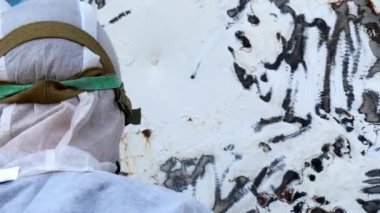 Tersanede tamirat sırasında işçiler metalin üzerindeki boyayı yırtıp atarlar. Çalışan işçi tulumları limandaki gemi tamirhanesinde yeniden inşa ediliyor..