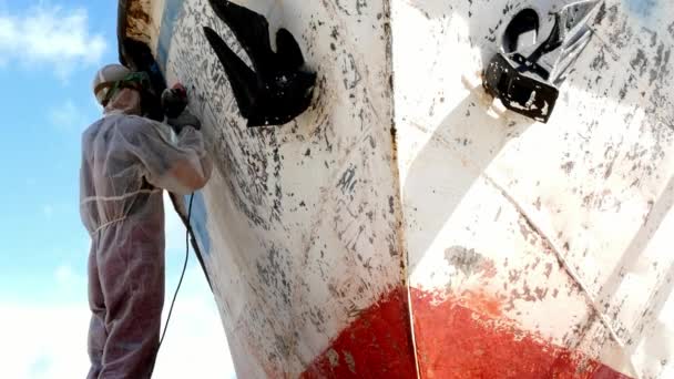 Workers tear off paint on metal in repairs process at shipyard. — Stock Video