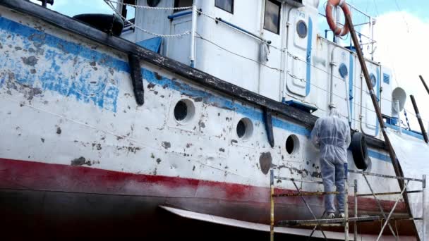 Les travailleurs arrachent la peinture sur le métal dans le processus de réparation au chantier naval. — Video