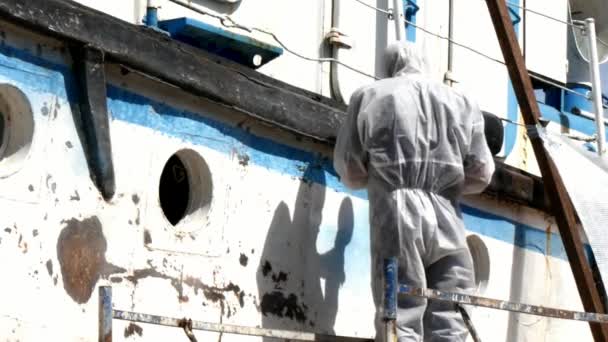 Arbetstagare sliter av färg på metall i reparationsprocessen vid varvet. — Stockvideo