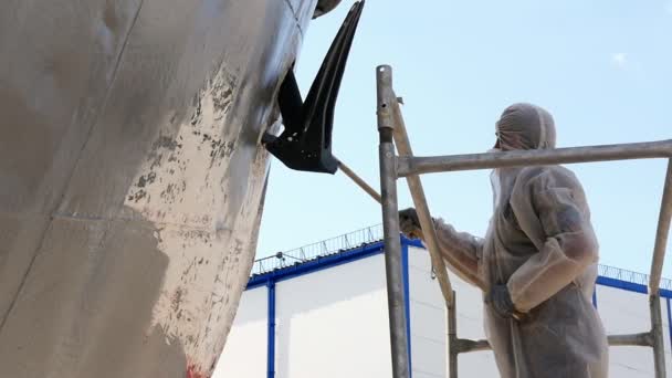 Arbetaren målar med pensel metall framsidan av fartyget på varv i hamnen i Moskva. — Stockvideo