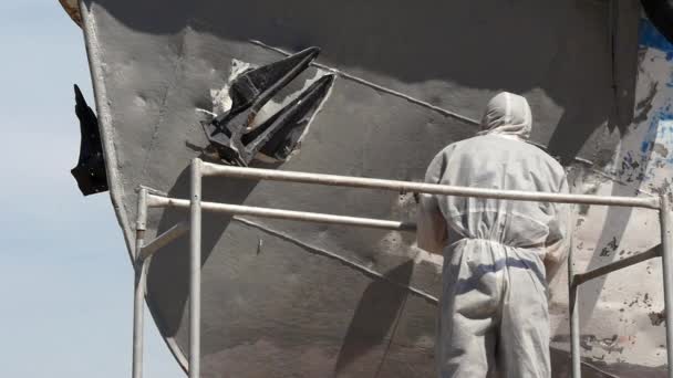 Worker paints with brush metal front of ship at shipyard in port of Moscow. — Stock Video