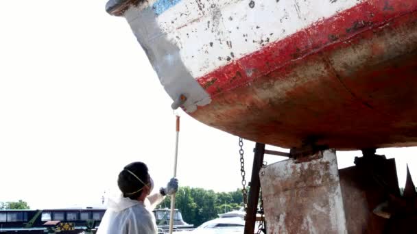 Arbetstagare omfattar metall med en primer färg av gammal rostig fartyget på varv i hamn. — Stockvideo