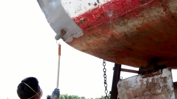 Il lavoratore copre il metallo con una vernice di fondo di vecchia nave arrugginita a cantiere navale in porto . — Video Stock