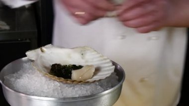 Aşçı deniz tarağı kabuk salata hazırlar..