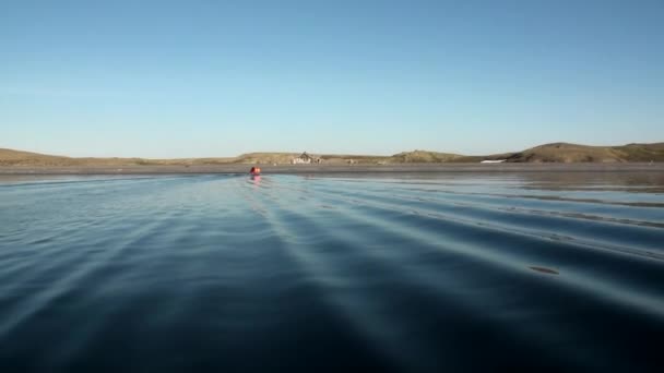 Les gens dans un bateau en caoutchouc dans l'océan sur la nouvelle terre Vaigach . — Video