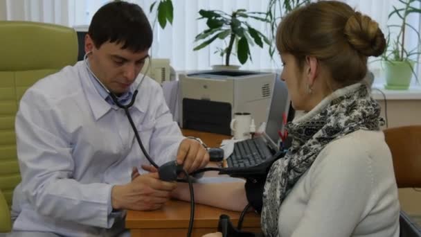 Médico de família mede a pressão arterial dos pacientes . — Vídeo de Stock