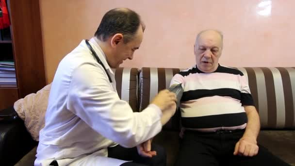 Lekarz rodzinny mierzy ciśnienie krwi u pacjentów. — Wideo stockowe