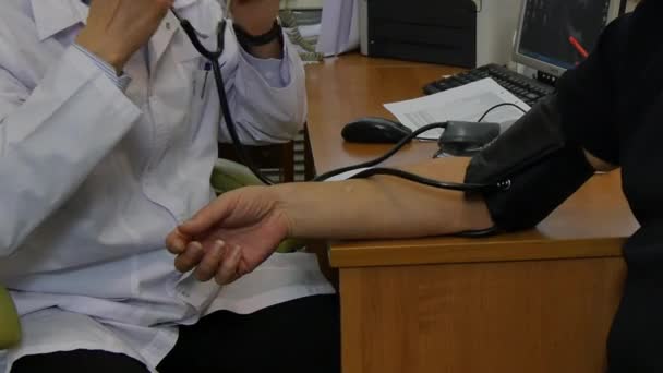 Doctor at hospital measures patients blood pressure. — Stock Video