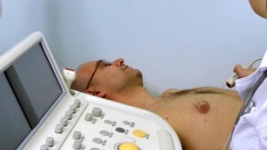 Kadın doktor hastane ameliyathanesinde modern ultrason ekokardiyografi cihazıyla hastaların kalbini muayene ediyor..