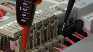 Eller işçinin fabrika elektronikte kişiler gerilim göstergesini denetleyin.