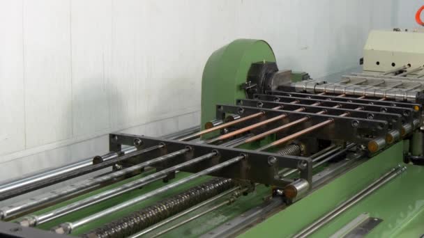 Bending and cutting metal copper pipes tubes on industrial CNC machine.