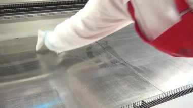 İşçi eldiven El buzdolabı vitrinin süpermarkette temizler.