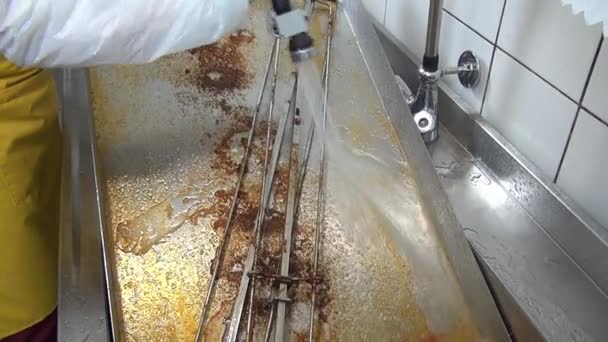 Mains de travailleur nettoie la graisse sur le gril industriel . — Video