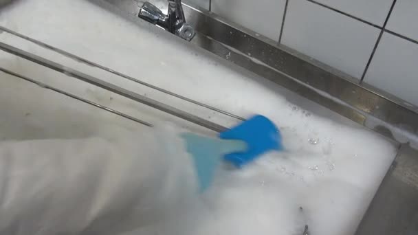 Cepillo azul en la mano del trabajador limpia parrilla de carne industrial . — Vídeos de Stock