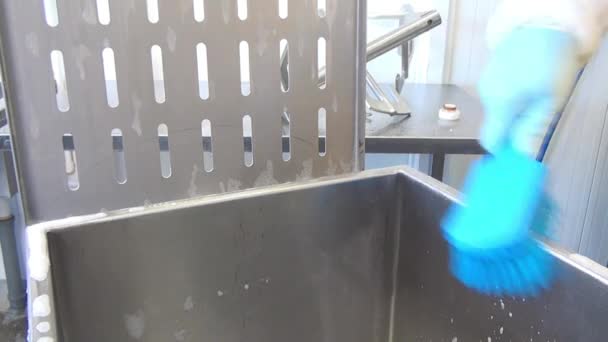 Синяя кисть в руке рабочего очищает промышленную мясорубку . — стоковое видео