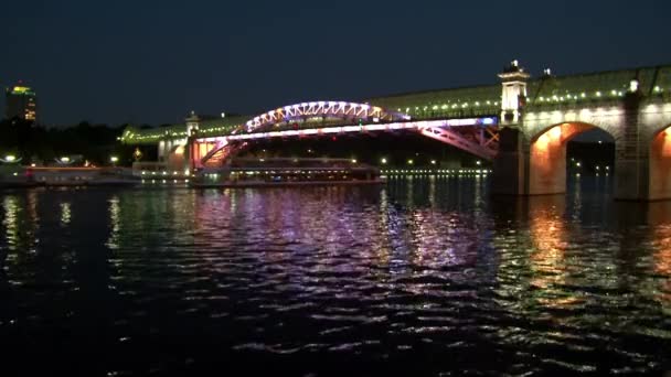 Dvě lodě plují pod mostem v večerní Moskva. — Stock video