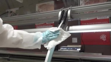 İşçinin el buzdolabı bir süpermarkette temizler.