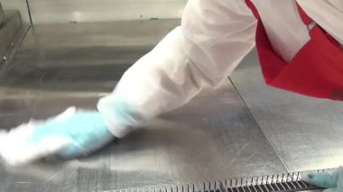 İşçinin el buzdolabı bir süpermarkette temizler.