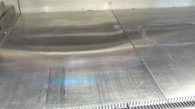 İşçinin el buzdolabı bir süpermarkette temizler.
