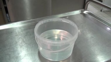 Eldiven elinde bez fabrikası suda ıslatıyor.