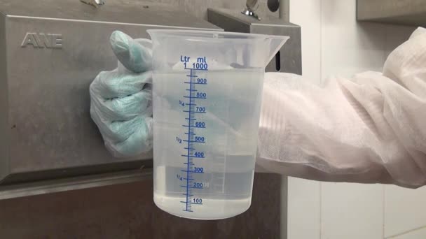 Meet het vat 1 liter met water. — Stockvideo