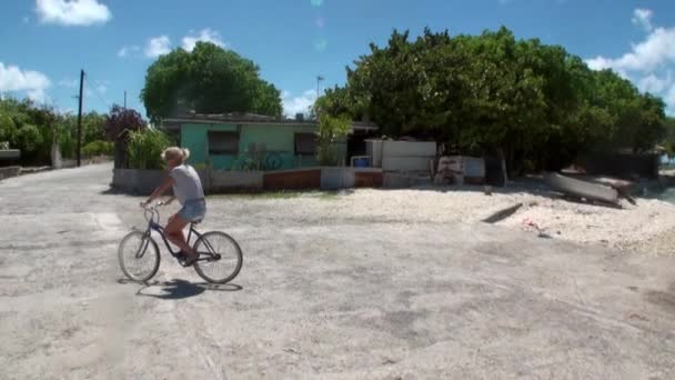 Mujer está montando una bicicleta en la carretera . — Vídeos de Stock