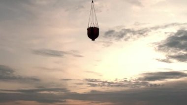 Sızıntı kepçesi askıya alınmış kargo yangın helikopteri rezervuardan uçuyor..