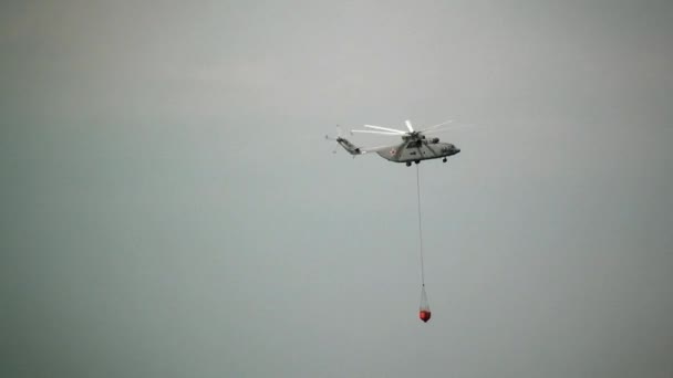 Πυροσβεστικό ελικόπτερο φορτίου με αιωρούμενη κουτάλα spillway πετά από δεξαμενή. — Αρχείο Βίντεο