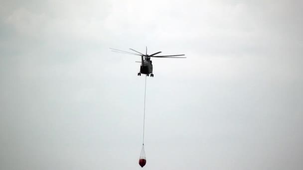 Helicóptero de incêndio de carga com concha suspensa está voando do reservatório. — Vídeo de Stock