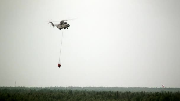 Helicóptero com concha suspensa voa para reservatório para entrada de água . — Vídeo de Stock