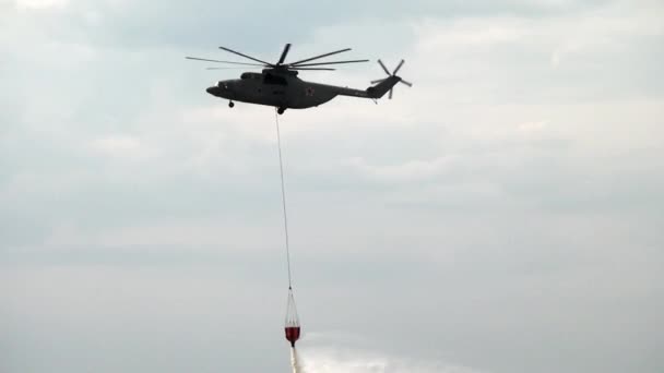 Vracht brandweerhelikopter met gesuspendeerde lepel vliegt uit reservoir. — Stockvideo