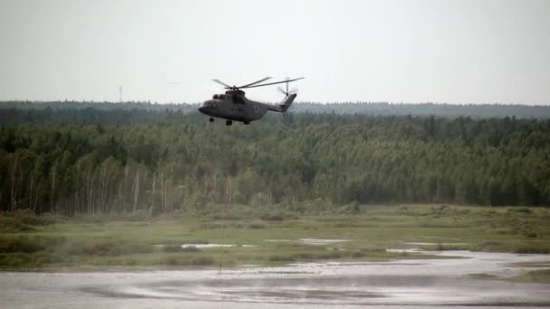 Frachtlöschhubschrauber mit schwebender Schöpfkelle holt Wasser aus Stausee. — Stockvideo