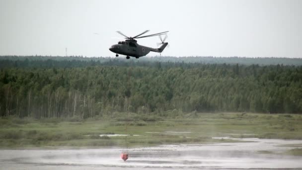 Helicóptero de incêndio de carga com concha suspensa leva água do reservatório . — Vídeo de Stock
