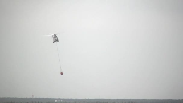 Hélicoptère d'incendie cargo avec poche anti-déversement suspendue prend l'eau du réservoir . — Video