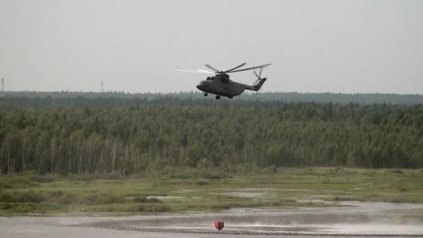 Lading brand helikopter met zwevende Noodoverlaat pollepel tapt water uit het reservoir. — Stockvideo