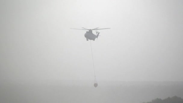 Cargo fire helikopter med svävande bräddavlopp slev tar vatten från behållaren. — Stockvideo