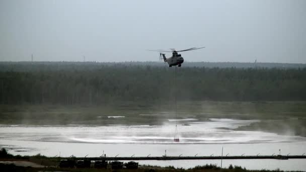 Ελικόπτερο Πυροσβεστική φορτίου με κουτάλα ανασταλεί υπερχειλιστή παίρνει νερό από την δεξαμενή. — Αρχείο Βίντεο
