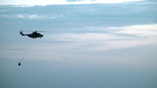 Helikopter strażacki ładunku z kadzi zawieszone przelew trwa wody ze zbiornika. — Wideo stockowe