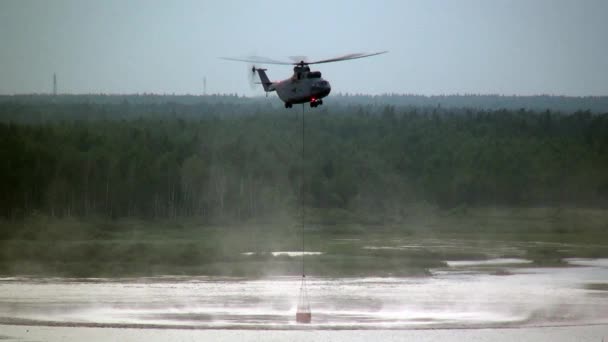 Helicóptero de incêndio de carga com concha suspensa leva água do reservatório . — Vídeo de Stock