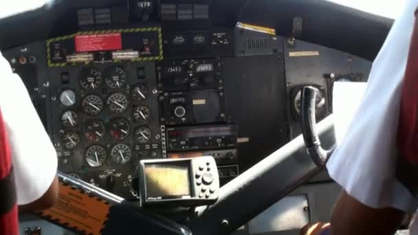 Вид ззаду на двох пілотів у літаковій кабіні на фоні вікна . — стокове відео