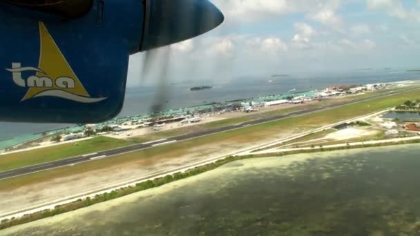 Šroub žluto modré letadlo otáčí na pozadí oceánu. — Stock video
