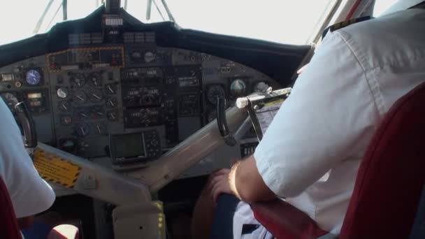 Vista desde atrás de dos pilotos en la cabina del avión en el fondo de la ventana . — Vídeo de stock