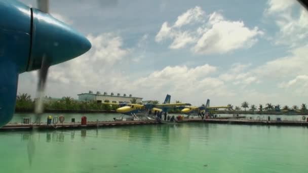 Vis de l'avion jaune-bleu tourne sur le fond de la jetée . — Video